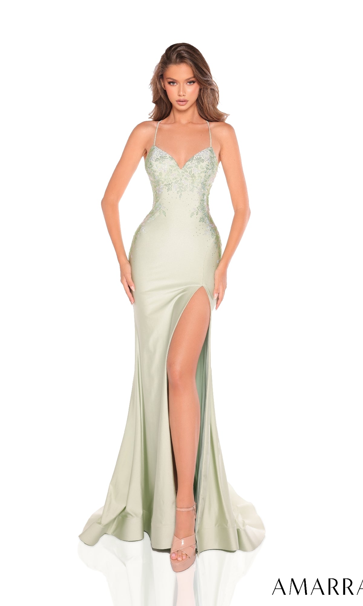 A woman models the Amarra 88235 Long Prom Dress—a light green, floor-length gown with thin straps, floral embroidery, a high slit, and a strappy open back—against a white background.